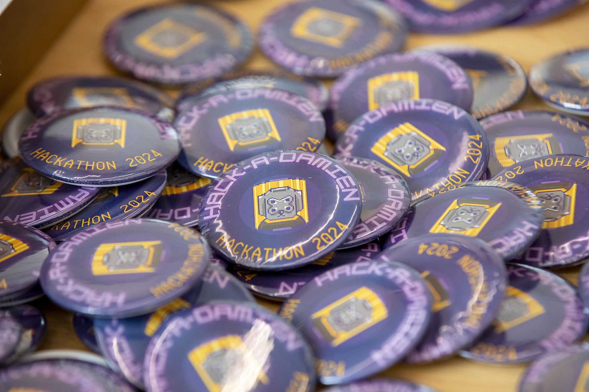 Pins with 'Hack-a-Damien are on display as UAlbany students host the University's first-ever hackathon at the ETEC building on April 13, 2024.